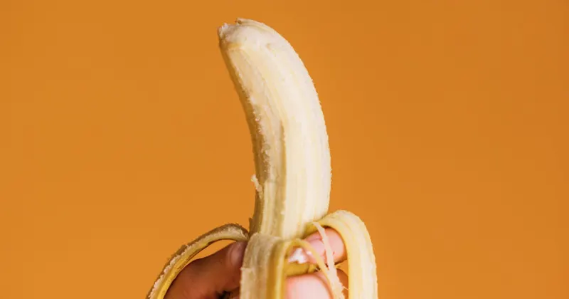 Person holding a fresh yellow banana for polishing hack