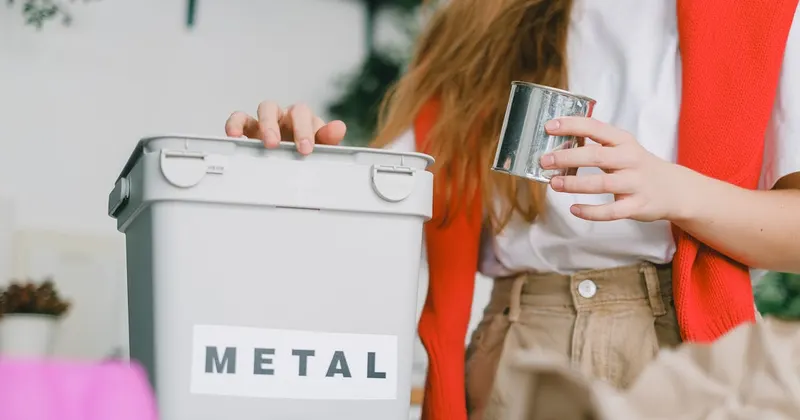 Woman sorting trash into recycling and composting bins at home