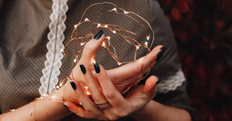 Person holding string of Christmas lights for seasonal storage