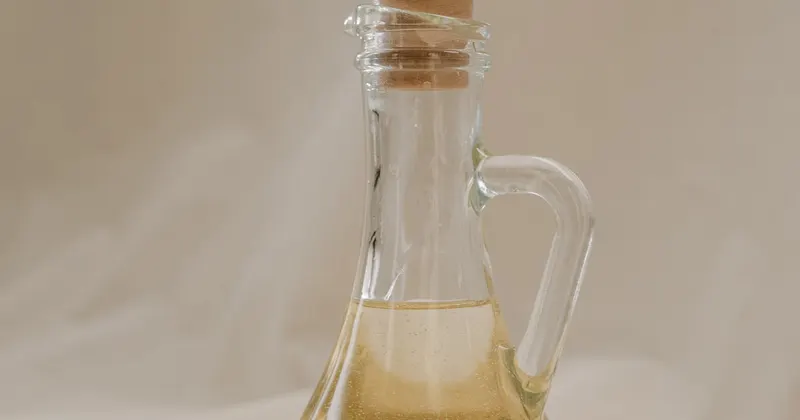 Clear glass bottle with olive oil on a kitchen surface