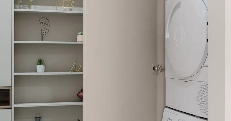 Washing machine and dryer stacked in a laundry cabinet