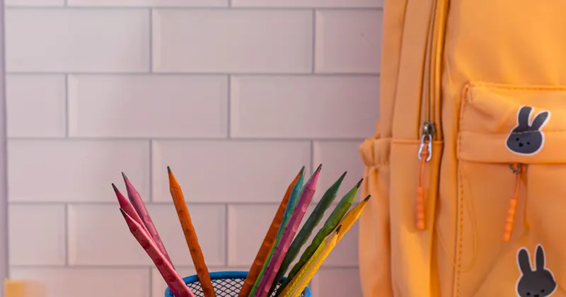 Bright school supplies with backpack and colored pencils on desk