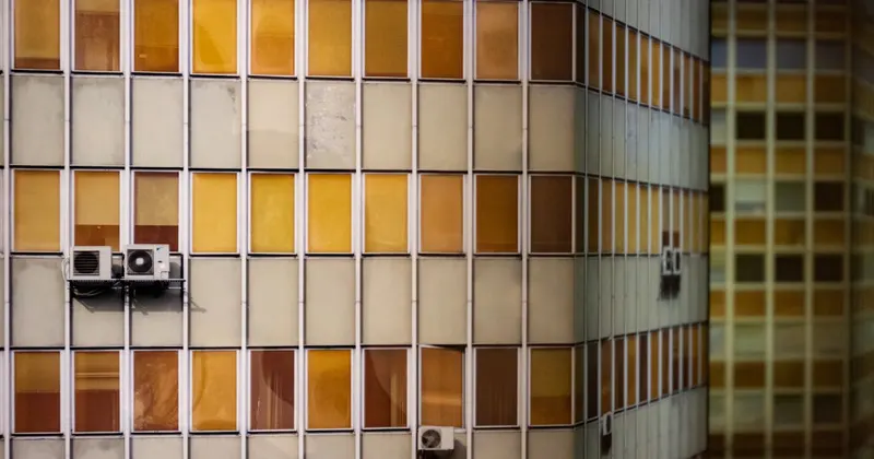 White outdoor AC condenser unit on the side of a building